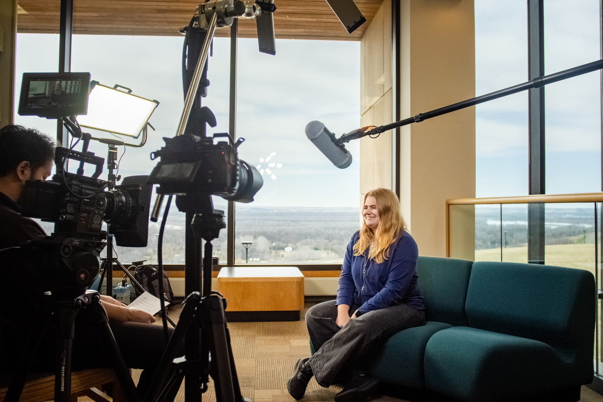 RecRoc crew filming a seated interview with cinema camera and boom mic, North Dakota